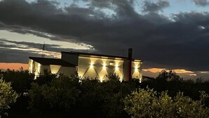 A modern building with a flat roof, a chimney, and multiple illuminated windows at dusk. - The tranquility of the countryside, just a stone's throw from the sea and the Selinunte Archaeological Park (Sicilia)