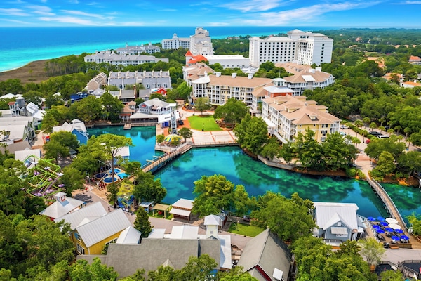 The resort layout integrates beautiful swimming pools, sun decks, and pedestrian footbridges seamlessly into nature.