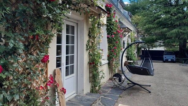 A house with a white door, a window, and a swing chair outside.