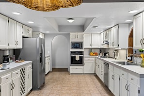 A modern kitchen with white cabinetry, stainless steel appliances, and a central island. - Hot Tub + Game Room + Sauna + Red Rock Views | Red Rock Sedona | Juniper Hideout (Sedona)