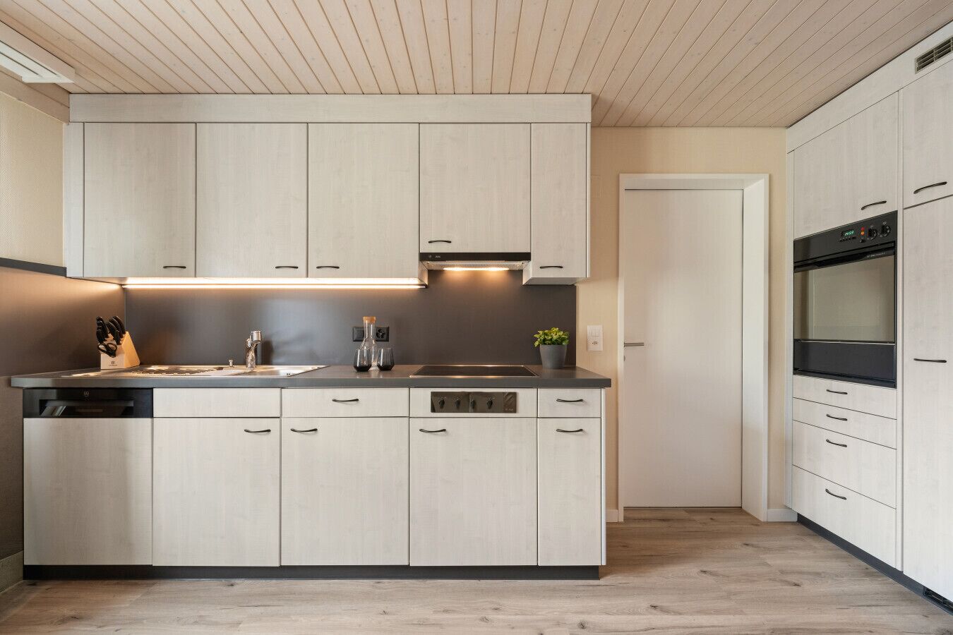Een koffiezetapparaat/waterkoker, een koelkast, een oven, een kookplaat
