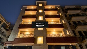 En flervåningsbyggnad med en skylt som visar texten: ”TOWNHOUSE – företag som erbjuder service”.