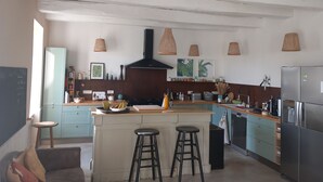 A modern kitchen with a central island, bar stools, a built-in oven, and pendant lights. - House in the heart of the village with a pool, near La Rochelle and Île de Ré (Vérines)