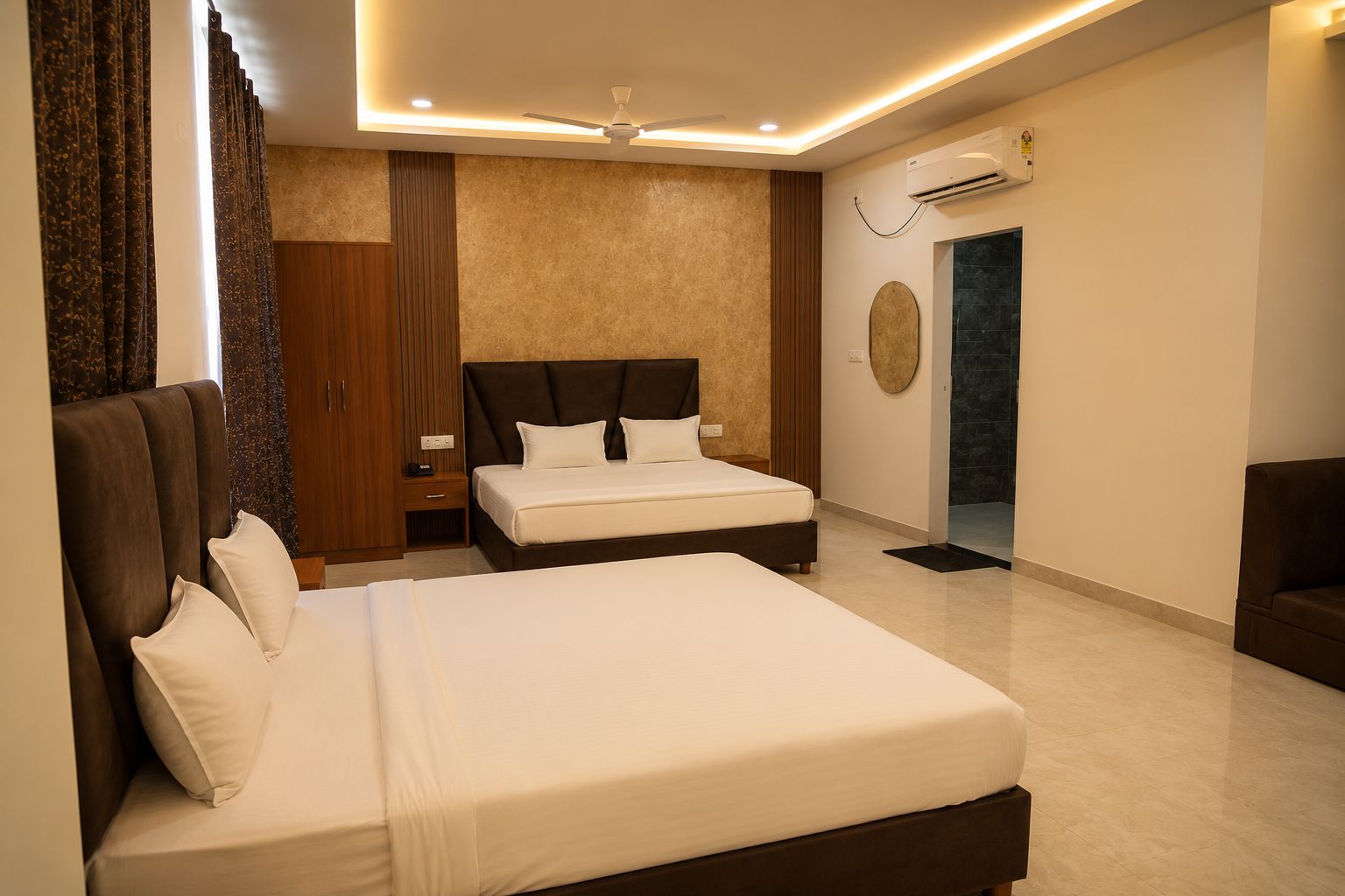 A hotel room with a double bed, a bedside table, a wardrobe, and a ceiling fan.