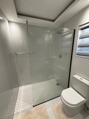 A modern bathroom with a glass-enclosed shower, a toilet, and a sink. - Private & Modern Studio Apartment in Sandton (Johannesburg)