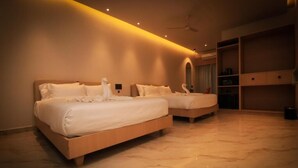 Una habitación de hotel moderna con dos camas, suelo de mármol y estanterías empotradas.