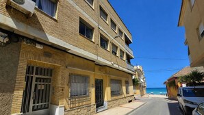 Un edificio de varios pisos con fachada de ladrillo, ventanas grandes y un balcón.