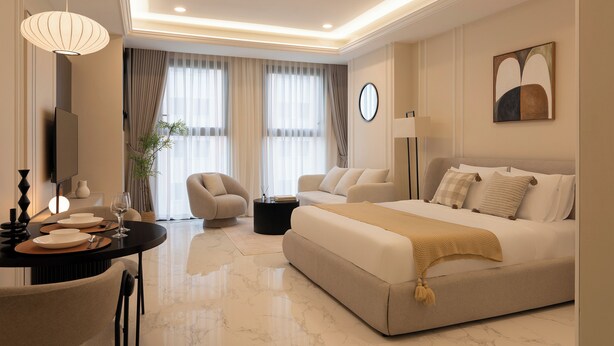 A modern hotel room with a bed, seating area, and a dining table. - Madison Grand Studio - King Bed - Pool & Gym access (Thành phố Hồ Chí Minh)