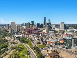 A cityscape with a mix of modern and historic buildings, a prominent red building, and a large dome structure. - Convention Centre Convenience - Wifi, Parking (Edmonton)