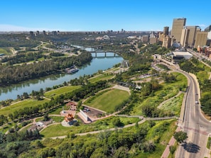 A cityscape with a river, green parks, and modern buildings. - Downtown Studio Near Rogers Place - Wifi, Parking (Edmonton)