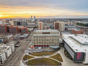 Eine Stadtansicht mit einer markanten Parkgarage und einem großen Gebäude mit einer gewölbten Dachform.