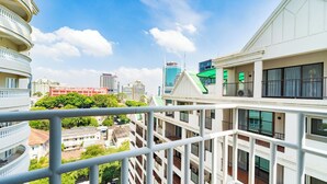 Um edifício alto com várias varandas e vista para a paisagem urbana.
