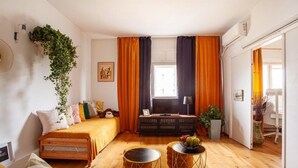 Un dormitorio acogedor con una cama, un escritorio y una ventana con cortinas.