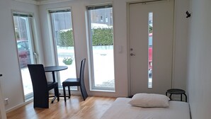 Een slaapkamer met een bed, een stoel, een tafel en een raam.