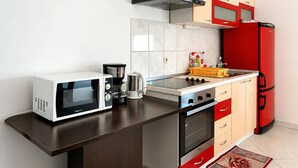 A kitchen with a microwave, coffee maker, stove, oven, and red refrigerator. - 1 bedroom beautiful apartment in Sabunike (Sabunike)