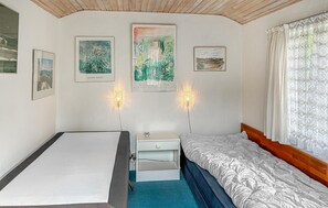 A bedroom with a bed, a nightstand, a dresser, and wall-mounted lights. - 3 bedroom amazing home in Jægerspris (Jægerspris)