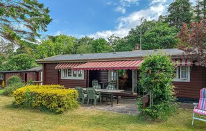 A wooden cabin with a porch, outdoor seating, and a garden. - 3 bedroom amazing home in Jægerspris (Jægerspris)