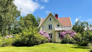 A two-story house with a red-tiled roof, a balcony, and a well-maintained lawn. - 4 Star Holiday Home in Hindas (Hindas)