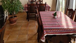 Ein Essbereich mit rundem Tisch, Stühlen, einer Topfpflanze und einer Wanddekoration.