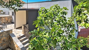 Un bâtiment moderne doté d’un escalier en pierre, de sièges en plein air et offrant une vue sur une colline.