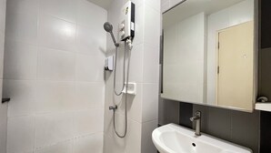 A bathroom with white tiles, a shower, a sink, and a mirror. - Room117atchangwattana (Pak Kret)