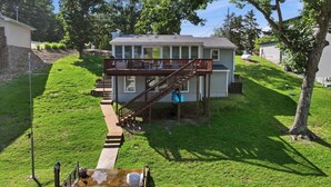Ein zweistöckiges Haus mit einer Terrasse, einer Treppe und einem kleinen Außenbereich mit Wasserspiel.