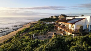 Una propiedad costera con terraza con vista a la playa, un letrero que dice 'African Perfection' y vista al océano.