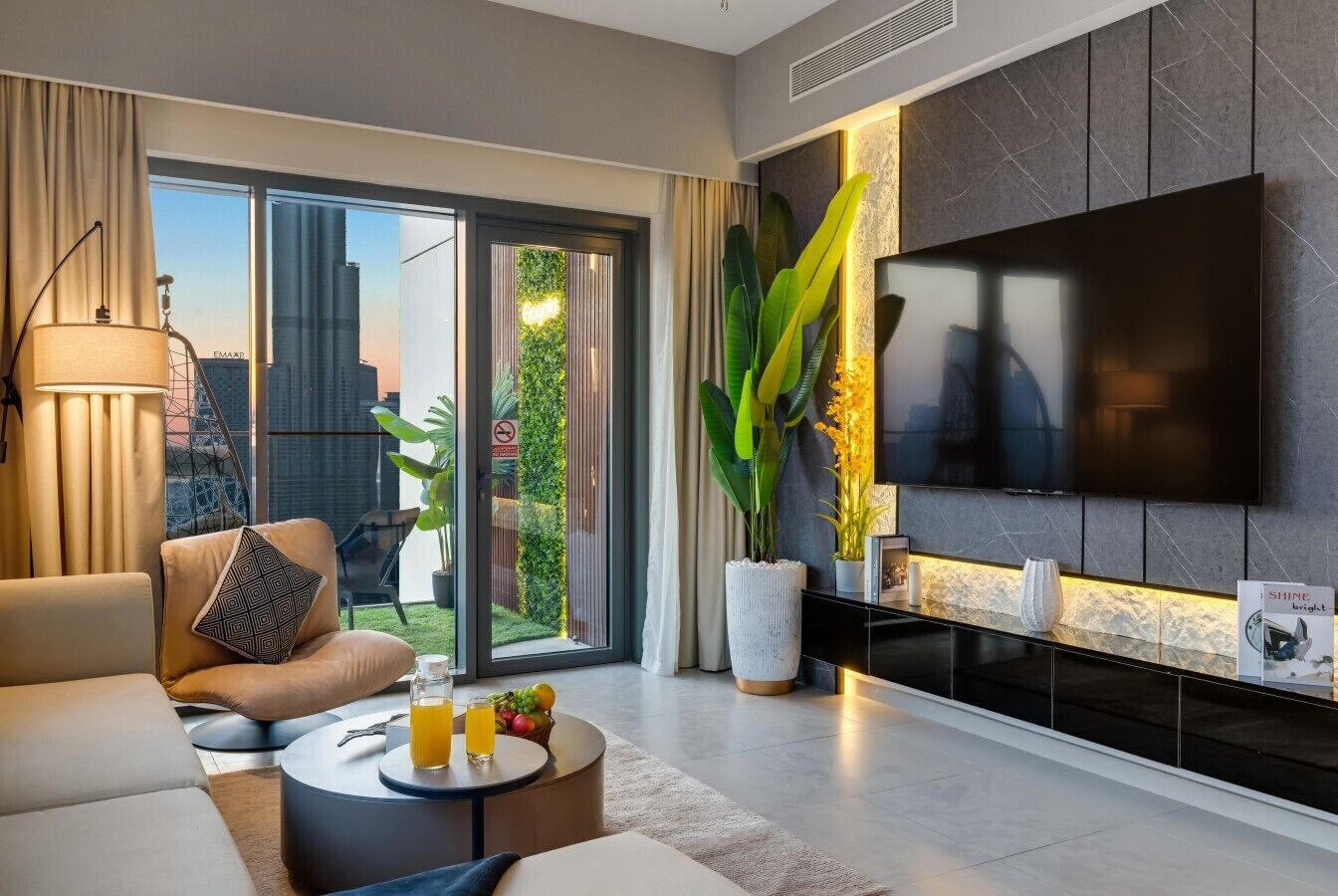 Ein modernes Wohnzimmer mit Sofa, Couchtisch und einem wandmontierten Flachbildfernseher.