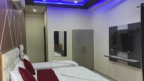 Een moderne slaapkamer met een bed, een plafondventilator, een televisie en een kledingkast.