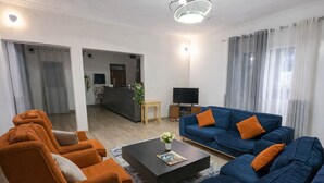 Una sala moderna con un sofá, una mesa de centro y un televisor.