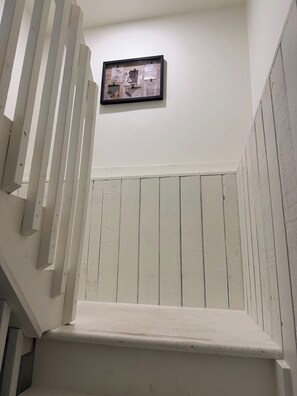 Eine Treppe mit weiß gestrichenen Stufen und einem an der Wand befestigten Bilderrahmen.