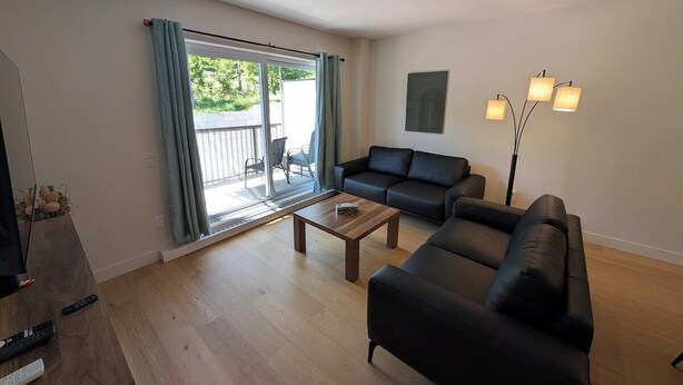 Un salon avec un canapé, une table basse et un lampadaire.