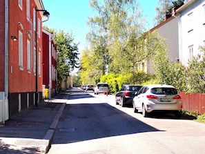 Eine Straße mit geparkten Autos und Gebäuden.