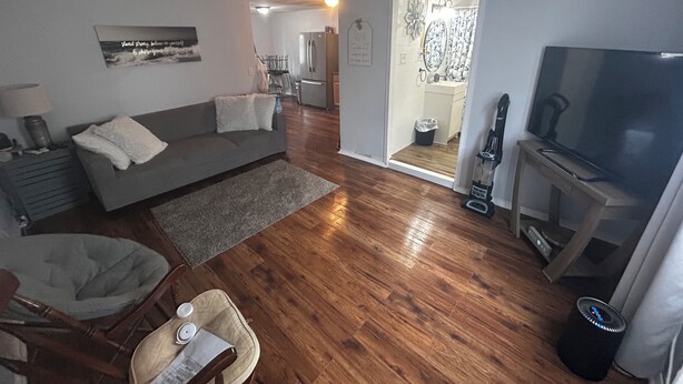 A living room with a sofa, a TV, a dining area with chairs, and a kitchen in the background. - Gorgeous 1-bedroom building with AC in friendly Seymour keypad entry (Seymour)