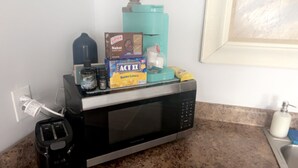 A kitchen with a microwave, toaster, and various food items on the counter. - Gorgeous 1-bedroom building with AC in friendly Seymour keypad entry (Seymour)