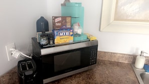 A kitchen with a microwave, toaster, and various food items on the counter. - Gorgeous 1-bedroom building with AC in friendly Seymour keypad entry (Seymour)