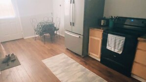 A kitchen with wooden flooring, a refrigerator, a microwave, and a sink. - Gorgeous 1-bedroom building with AC in friendly Seymour keypad entry (Seymour)