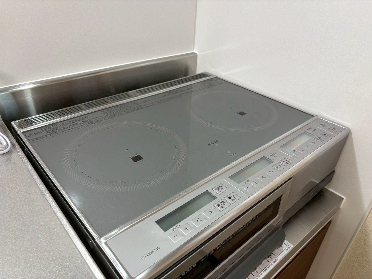 A kitchen with a built-in induction cooktop and a digital control panel.