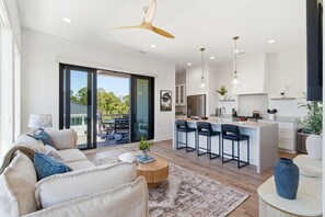 Una sala moderna con sofá, mesa de centro y vistas al exterior.