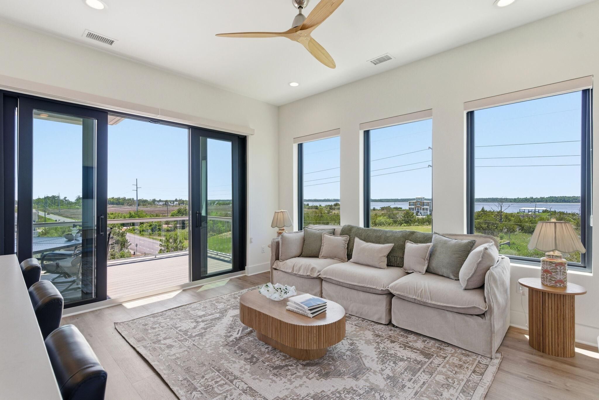 A spacious living room with a large sofa, a coffee table, and a ceiling fan.