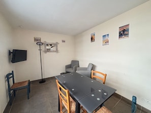 Ein Essbereich mit Tisch, Stühlen, einer Stehlampe und Wandgestaltungen.