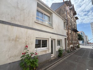 Ein Gebäude mit einer modernen Fassade, großen Fenstern und einem kleinen Eingang.