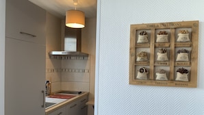 Eine moderne Küche mit einem Holzkasten, einem eingebauten Backofen und einer Hängeleuchte.