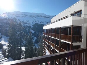 A modern building with multiple balconies overlooking a snowy mountain landscape. - Spacious apartment, pool access - 6 guests (Flaine)