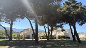 A residential area with multi-story buildings, a playground, and trees. - Ideal apartment beach access + pool (Poggio-Mezzana)