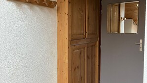 Une porte en bois ornée d’un petit miroir et d’un motif en forme de cœur sur le mur.