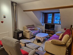 A cozy living room with a sofa, armchairs, a TV, and a fireplace. - Duplex apartment for 8/10 pers, 150m from cable car (Cauterets)