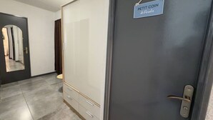 Ein Zimmer mit Schrank, einer Tür mit Schild und einem Spiegel.