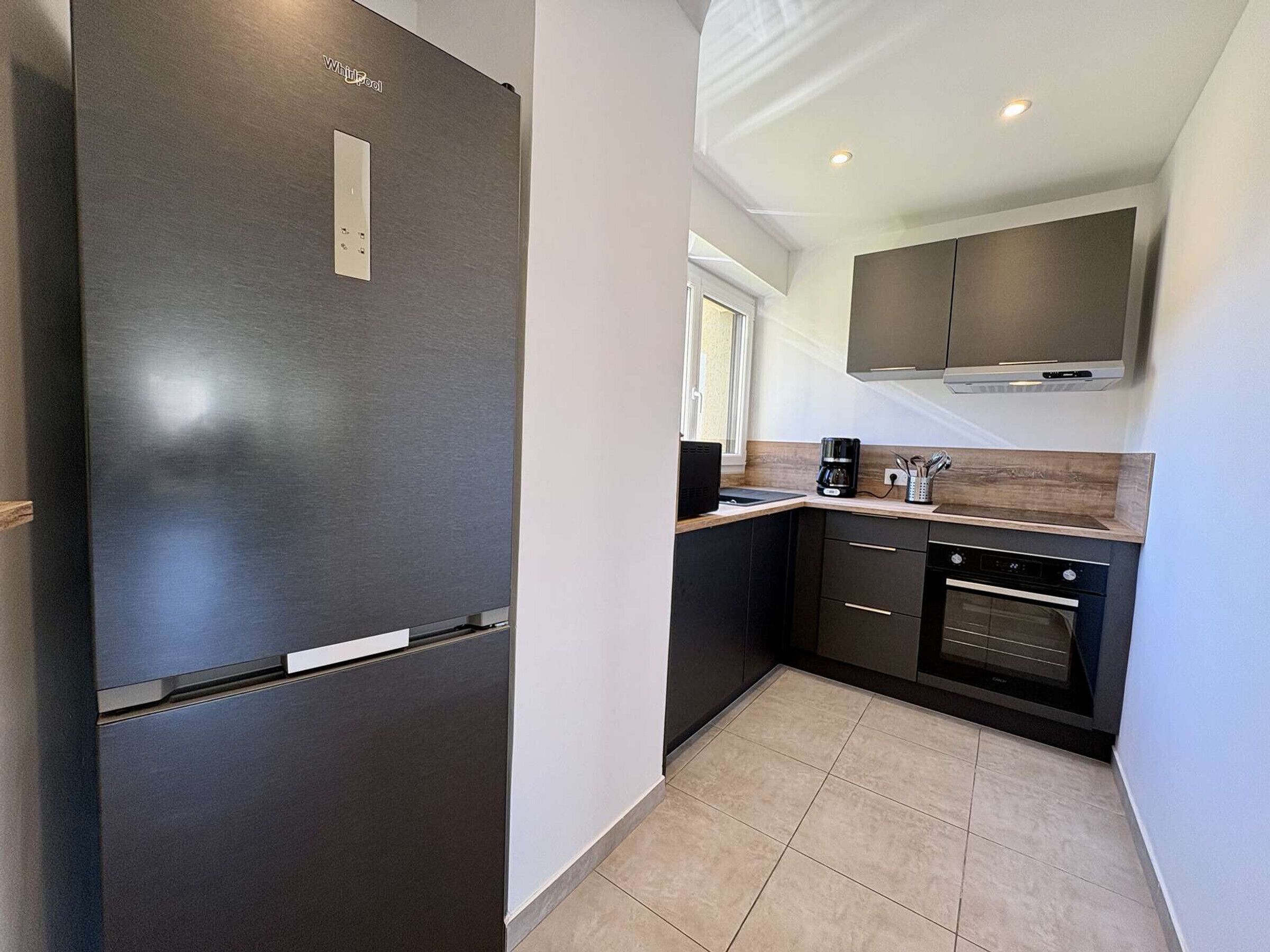 A modern kitchen with a built-in refrigerator, a coffee maker, and a microwave.