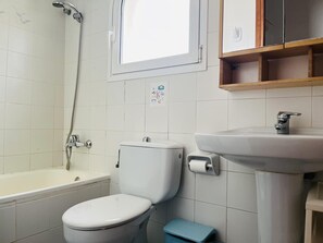 Une salle de bain avec une baignoire, des toilettes et un lavabo.
